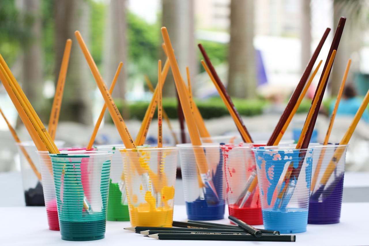 pexels-photo-542556 Vibrant paint brushes and pencils in plastic cups for arts and crafts.